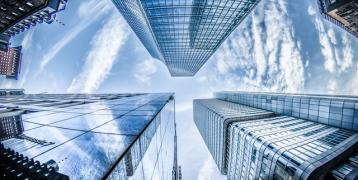 View up high rise buildings with reflecting glass